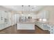 Spacious kitchen featuring stainless appliances, granite counters, an island, and ample white cabinetry at 2031 W Periwinkle Way, Chandler, AZ 85248
