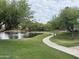 Picturesque community pond with winding pathway, a small bridge, and lush green landscaping at 2031 W Periwinkle Way, Chandler, AZ 85248