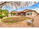 Spacious backyard showcasing a pool, outdoor dining area, lush lawn, and mature trees, offering an ideal setting for relaxation at 20423 S 186Th St, Queen Creek, AZ 85142