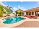Lush backyard featuring a sparkling pool, mature palm trees, and cozy outdoor seating at 20423 S 186Th St, Queen Creek, AZ 85142