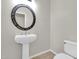 Half bathroom with pedestal sink, decorative mirror, and toilet at 20423 S 186Th St, Queen Creek, AZ 85142