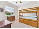 Bright bedroom features a wooden bunk bed with pull-out drawers and a large sunny window at 20423 S 186Th St, Queen Creek, AZ 85142