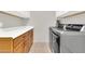 Convenient laundry room with ample counter space, wooden cabinets, and modern washer/dryer at 20423 S 186Th St, Queen Creek, AZ 85142