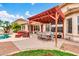Inviting backyard patio with a charming pergola, an outdoor dining set, and relaxing seating near the lush lawn at 20423 S 186Th St, Queen Creek, AZ 85142