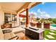 Covered patio with outdoor kitchen, grill, and a cozy seating area, overlooking a well-manicured lawn and entertainment area at 20423 S 186Th St, Queen Creek, AZ 85142