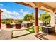Inviting covered patio with comfortable seating, a stylish fire pit, and views of the lush lawn and serene pool area at 20423 S 186Th St, Queen Creek, AZ 85142