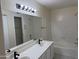 Bright bathroom featuring a double sink vanity with a large mirror, a shower-tub combo, and tiled walls at 2100 W Lemon Tree Pl # 29, Chandler, AZ 85224
