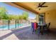 Backyard features covered patio, pool with safety fence, and mature landscaping at 22184 N 101St Dr, Peoria, AZ 85383