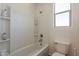Bright bathroom with a shower-tub, a window, and a toilet at 22184 N 101St Dr, Peoria, AZ 85383