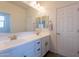 Bright bathroom featuring double sinks, white cabinets and a large mirror at 22184 N 101St Dr, Peoria, AZ 85383
