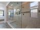 Tiled bathroom features an expansive walk-in shower with glass enclosure at 22184 N 101St Dr, Peoria, AZ 85383