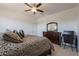 Bedroom featuring a ceiling fan, a dresser with mirror, and desk space at 22184 N 101St Dr, Peoria, AZ 85383