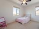 Bright bedroom with a cozy bed, large windows, and a playful art easel at 22184 N 101St Dr, Peoria, AZ 85383