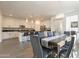 Open-concept space showcasing the dining area and white kitchen with pendant lighting at 22184 N 101St Dr, Peoria, AZ 85383