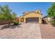 Two story home with a charming yellow exterior and brown garage door, complemented by a brick driveway and low maintenance yard at 22184 N 101St Dr, Peoria, AZ 85383