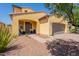 Home with a charming yellow exterior, well-maintained desert landscaping, and a welcoming front entrance at 22184 N 101St Dr, Peoria, AZ 85383