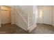 Foyer featuring wood look tile flooring, a staircase with a baby gate, and neutral decor at 22184 N 101St Dr, Peoria, AZ 85383