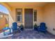 Cozy front porch featuring a tiled floor, two blue Adirondack chairs, and a welcoming atmosphere at 22184 N 101St Dr, Peoria, AZ 85383