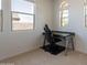 Dedicated home office space with a modern desk, ergonomic chair, and natural light from the windows at 22184 N 101St Dr, Peoria, AZ 85383