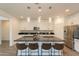 Kitchen island with barstool seating, white cabinets, dark countertops, and stainless appliances at 22184 N 101St Dr, Peoria, AZ 85383