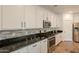 Modern kitchen features stainless steel appliances, granite countertops, and sleek white cabinetry at 22184 N 101St Dr, Peoria, AZ 85383