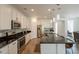 Open kitchen with island, granite counters, stainless appliances, and pendant lighting at 22184 N 101St Dr, Peoria, AZ 85383