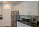 Kitchen featuring stainless steel refrigerator, granite counters and white cabinets at 22184 N 101St Dr, Peoria, AZ 85383