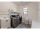 Well-equipped laundry room with modern washer and dryer and sink at 22184 N 101St Dr, Peoria, AZ 85383