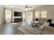 Bright living room with a ceiling fan, tile flooring, and sliding glass doors to the outside at 22184 N 101St Dr, Peoria, AZ 85383