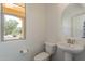Bright powder room with natural light, featuring a pedestal sink and neutral decor at 22184 N 101St Dr, Peoria, AZ 85383