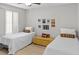 Bright bedroom featuring two twin beds, modern ceiling fan, and white plantation shutters at 2363 Leisure World --, Mesa, AZ 85206