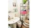 Functional bathroom with a pedestal sink, toilet, and storage shelving for organization at 2377 W Hazelwood St, Phoenix, AZ 85015
