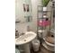 Bathroom with a functional pedestal sink, toilet, and shelving for storage and decor at 2377 W Hazelwood St, Phoenix, AZ 85015