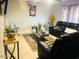 Bright living room with tile floors, leather furniture, and an elegant glass coffee table at 2377 W Hazelwood St, Phoenix, AZ 85015