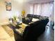 A living room featuring leather couches, a decorative table, a plant, and a sliding glass door at 2377 W Hazelwood St, Phoenix, AZ 85015