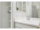 A modern bathroom showcases a clean white vanity, bright lighting, and open shelving for added storage at 24105 W Flores Dr, Buckeye, AZ 85326