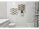 Bathroom features a toilet, shower with striped curtains, geometric decor, and towel rack at 24105 W Flores Dr, Buckeye, AZ 85326
