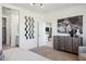 Open bedroom layout with art pieces, contemporary dresser, and a view to the bathroom at 24105 W Flores Dr, Buckeye, AZ 85326