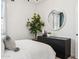 Stylish bedroom with a modern dresser, mirror, and indoor plant, creating a serene space at 24105 W Flores Dr, Buckeye, AZ 85326