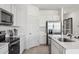 Modern kitchen featuring stainless steel appliances, white cabinets, and stone countertops at 24105 W Flores Dr, Buckeye, AZ 85326