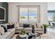 Inviting living room featuring a plush sectional sofa, decorative pillows, and a view to the outdoors at 24105 W Flores Dr, Buckeye, AZ 85326