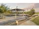 A picnic area in the neighborhood with tables, sunshade, and lush greenery, perfect for outdoor gathering at 24105 W Flores Dr, Buckeye, AZ 85326