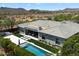 Serene aerial view of a well-maintained backyard with a pool, manicured lawn, and desert landscape at 2821 E Cashman Dr, Phoenix, AZ 85050
