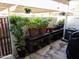 View of patio area with bench, various potted plants, an AC unit, and a covered grill at 2927 N Oregon St # 7, Chandler, AZ 85225