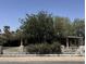 Modest single story home behind a decorative block wall with a tree filled front yard at 3112 W Taylor St, Phoenix, AZ 85009