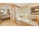 Luxurious bathroom with soaking tub, tile surround, and decorative window at 3538 E Squawbush Pl, Phoenix, AZ 85044