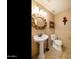 Elegant powder room with pedestal sink, decorative mirror, and classic fixtures create a refined space at 3538 E Squawbush Pl, Phoenix, AZ 85044