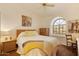 Bright bedroom with arched window, comfortable queen bed, side tables, and warm decor for relaxation at 3538 E Squawbush Pl, Phoenix, AZ 85044