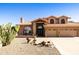 Inviting home featuring desert landscaping, a tile roof, arched windows and a three car garage at 3538 E Squawbush Pl, Phoenix, AZ 85044