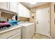 Bright laundry room with white cabinets, tile floor, washer, dryer, and plenty of storage space at 3538 E Squawbush Pl, Phoenix, AZ 85044